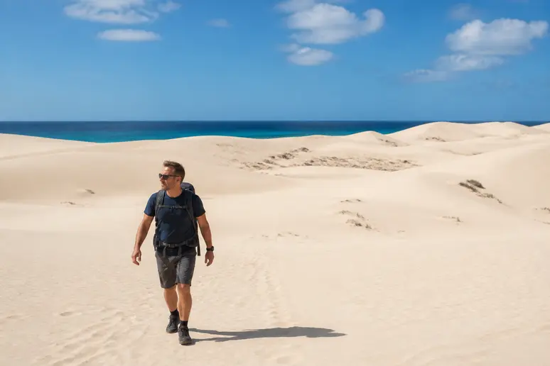 Homme explorant des dunes de sable blanc à boa vista cap vert, paysage désertique