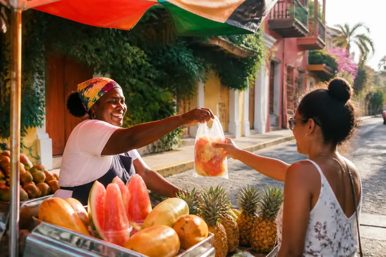 Vendeuse de fruits tropicaux à Carthagène Colombie, souriante sous le soleil caribéen.