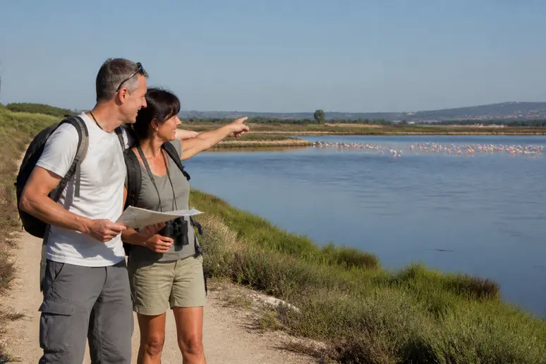 Couple d'amis observant des flamants roses près des salines, découverte de vic la gardiole.