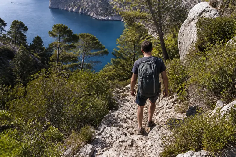 Sentier de randonnée escarpé descendant vers la calanque d'En-Vau dans le massif rocheux