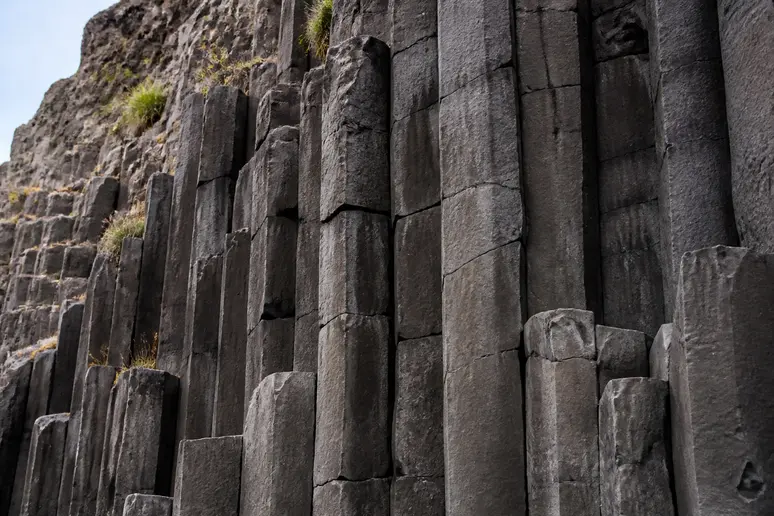 Orgues basaltiques verticaux et sombres formant une structure géologique volcanique remarquable.