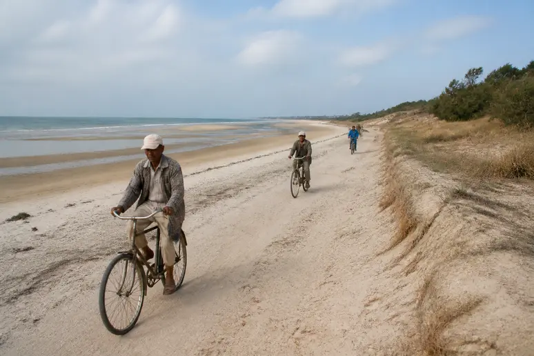 Cyclistes empruntant les sentiers côtiers près de la plage de la Conche des Baleines à marée basse