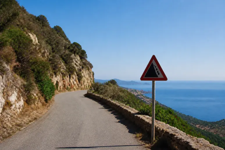 Panneau de signalisation et route côtière menant à la plage d'Arone