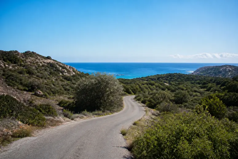 Route départementale sinueuse menant à la plage de Cupabia à travers le maquis corse