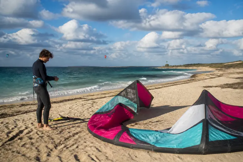 Kitesurfeur préparant son matériel sur le sable de la plage de l'Almanarre par vent fort
