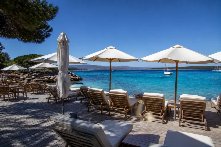 Terrasse de restaurant et transats installés directement sur la plage de Verghia